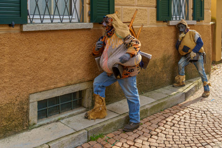 Schignano, Italy - February 18, 2023: Participants in traditional costume and mask, part of the traditional carnival of Schignano, Lake Como, Lombardy, Northern Italyのeditorial素材