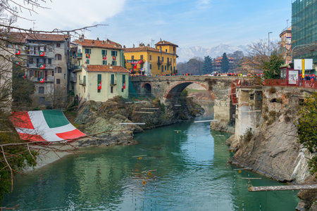 Ivrea, Italy - February 19, 2023: View of the old bridge (Ponte Vecchio) with crowd, during the historical carnival of Ivrea, Piedmont, Northern Italyのeditorial素材