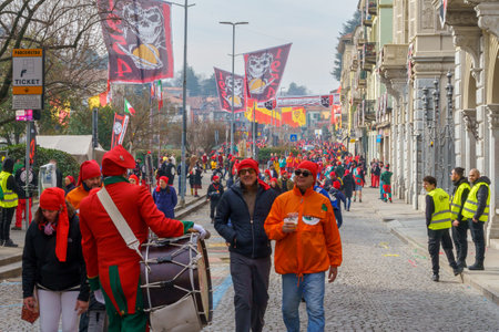 Ivrea, Italy - February 19, 2023: Street crowded with people with red hats, during the historical carnival of Ivrea, Piedmont, Northern Italyのeditorial素材