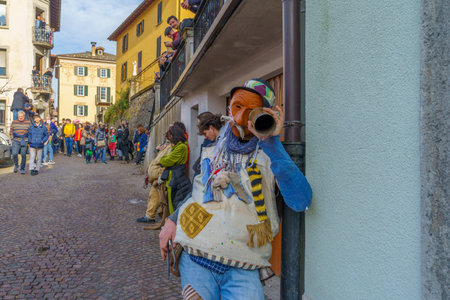 Schignano, Italy - February 18, 2023: Participants in traditional costumes and mask, and spectators, part of the traditional carnival of Schignano, Lake Como, Lombardy, Northern Italyのeditorial素材