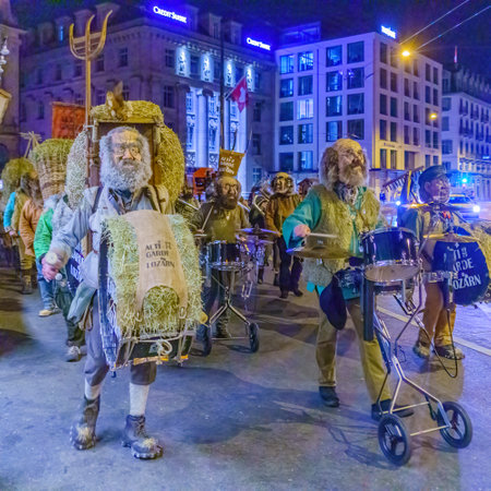 Lucerne, Switzerland - February 20, 2023: Band of musicians in costumes march in the streets, part of an early morning parade of the Fasnacht Carnival, in Lucerne (Luzern), Switzerlandのeditorial素材