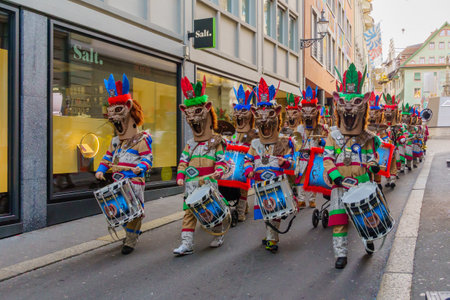 Lucerne, Switzerland - February 20, 2023: Band of musicians in costumes march in the streets, and crowd, part of the Fasnacht Carnival, in Lucerne (Luzern), Switzerlandのeditorial素材