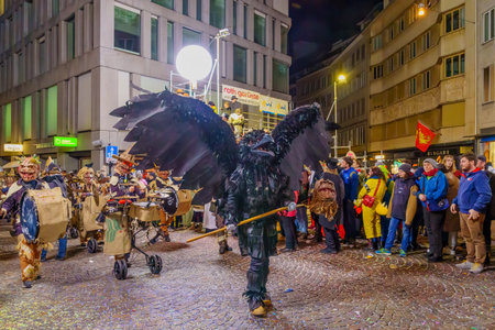 Lucerne, Switzerland - February 21, 2023: Band of musicians in costumes march in the streets, part of the final night parade of the Fasnacht Carnival, in Lucerne (Luzern), Switzerlandのeditorial素材