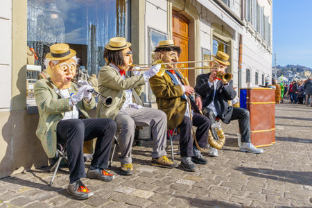 Lucerne, Switzerland - February 20, 2023: Band of musicians in costumes play to the crowd, part of the Fasnacht Carnival, in Lucerne (Luzern), Switzerlandのeditorial素材