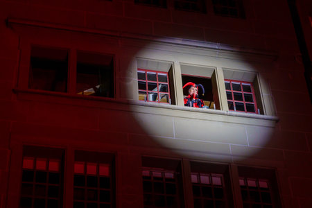 Bern, Switzerland - February 23, 2023: People in costumes perform the waking of the bear ceremony, in the Kafigturm tower, as part of the carnival of Bern, Switzerlandのeditorial素材
