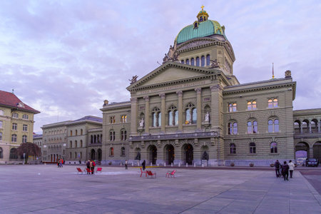 Bern, Switzerland - February 23, 2023: Sunset view of the Parliament Building (Bundeshaus), with locals, and visitors, in Bern, Switzerlandのeditorial素材