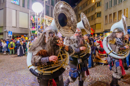 Lucerne, Switzerland - February 21, 2023: Band of musicians in costumes march in the streets, part of the final night parade of the Fasnacht Carnival, in Lucerne (Luzern), Switzerlandのeditorial素材