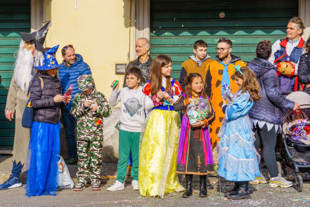 Cantu, Italy - February 25, 2023: Spectators in costumes attend the carnival parade, in Cantu, Lombardy, Northern Italyのeditorial素材