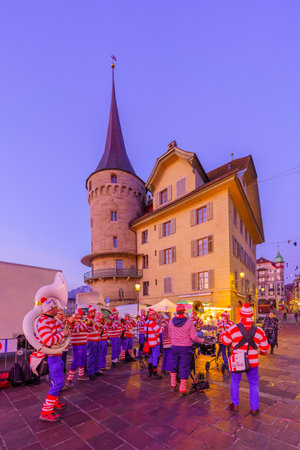 Lucerne, Switzerland - February 20, 2023: Band of musicians in costumes and crowd, at sunrise, part of the Fasnacht Carnival, in Lucerne (Luzern), Switzerlandのeditorial素材