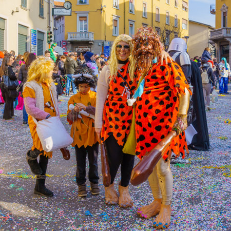 Cantu, Italy - February 25, 2023: Carnival parade, with family in flintstones costumes, in Cantu, Lombardy, Northern Italyのeditorial素材