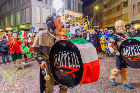 Lucerne, Switzerland - February 21, 2023: Band of musicians in costumes march in the streets, part of the final night parade of the Fasnacht Carnival, in Lucerne (Luzern), Switzerlandのeditorial素材