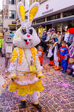 Lucerne, Switzerland - February 21, 2023: Group of participants in costumes march in the streets, and crowd, part of the children parade of the Fasnacht Carnival, in Lucerne (Luzern), Switzerlandのeditorial素材
