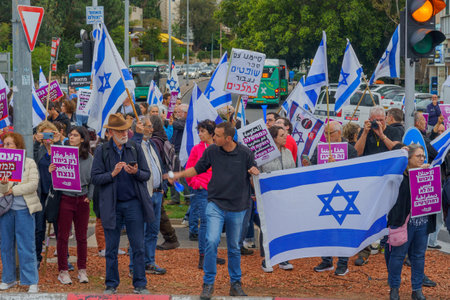 Haifa, Israel - March 23, 2023: Protesters with various signs and flags take part in a nationwide shutdown day, against the plans of the new government, claiming its anti-democratic, in Haifa, Israelのeditorial素材