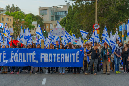 Haifa, Israel - March 25, 2023: Protest march with various banners, signs and flags as demonstration against the plans of the new government, claiming its anti-democratic, in Haifa, Israelのeditorial素材