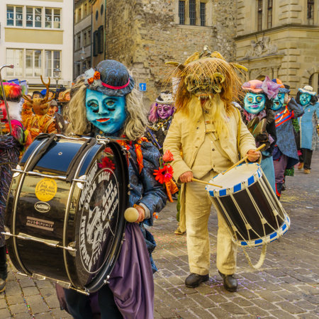 Lucerne, Switzerland - February 20, 2023: Band of musicians in costumes march in the streets, and crowd, part of the Fasnacht Carnival, in Lucerne (Luzern), Switzerlandのeditorial素材