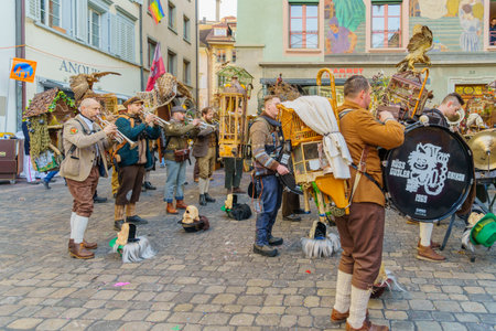 Lucerne, Switzerland - February 20, 2023: Band of musicians in costumes play to the crowd, part of the Fasnacht Carnival, in Lucerne (Luzern), Switzerlandのeditorial素材