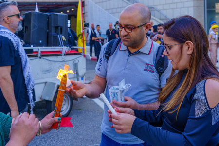 Haifa, Israel - April 15, 2023: Holy fired being held and shared by locals, in Orthodox Easter Holy Saturday celebration in Haifa, Israelのeditorial素材