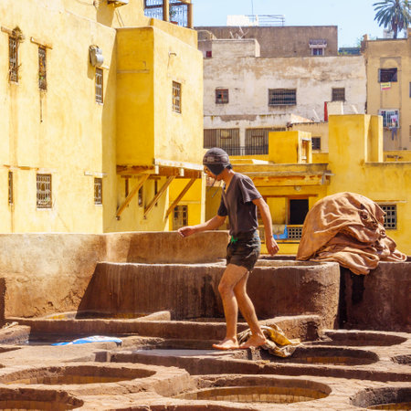 Fes, Morocco - March 31, 2023: Scene of the leather tannery, with workers and stone vats filled with various colors. Fes, Moroccoのeditorial素材
