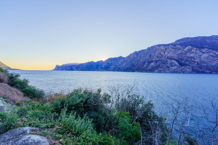 Sunset view of the north shore of Lake Garda, on a clear winter day, in NagoâTorbole, Trentino, Northern Italyの写真素材
