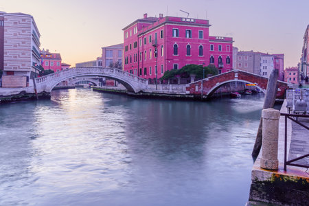 Sunrise view of colorful buildings, canals, boats, and bridges, in Venice, Veneto, Northern Italyの写真素材