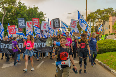 Haifa, Israel - May 20, 2023: People marching with flags and various signs. 20th week of anti-government protest in Haifa, Israelのeditorial素材