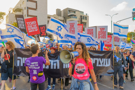 Haifa, Israel - May 20, 2023: People marching with flags and various signs. 20th week of anti-government protest in Haifa, Israelのeditorial素材