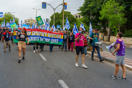 Haifa, Israel - May 27, 2023: People marching with flags and various signs. Week 21 of anti-government protest in Haifa, Israelのeditorial素材