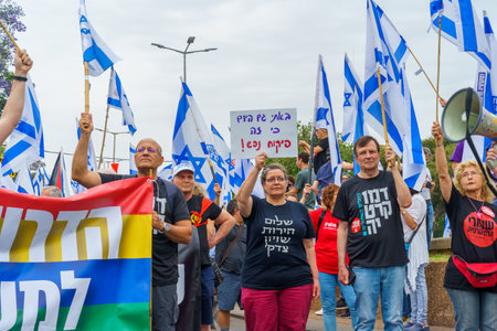 Haifa, Israel - May 27, 2023: People marching with flags and various signs. Week 21 of anti-government protest in Haifa, Israelのeditorial素材