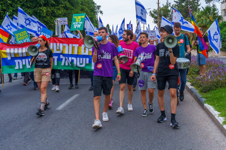 Haifa, Israel - May 27, 2023: People marching with flags and various signs. Week 21 of anti-government protest in Haifa, Israelのeditorial素材