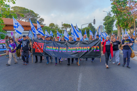 Haifa, Israel - June 10, 2023: People marching with flags and various signs. 23rd week of anti-government protest in Haifa, Israelのeditorial素材