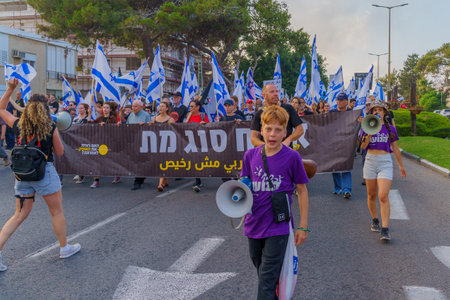 Haifa, Israel - June 10, 2023: People marching with flags and various signs. 23rd week of anti-government protest in Haifa, Israelのeditorial素材