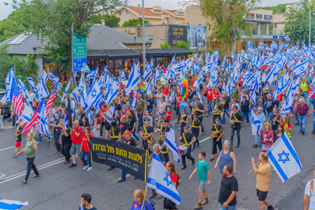 Haifa, Israel - June 17, 2023: People marching with flags and various signs. Week 24 of anti-government protest in Haifa, Israelのeditorial素材