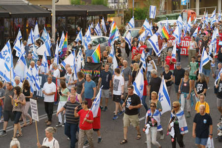 Haifa, Israel - June 24, 2023: People marching with flags and various signs. Week 25 of anti-government protest in Haifa, Israelのeditorial素材