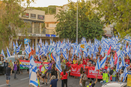 Haifa, Israel - June 24, 2023: People marching with flags and various signs. Week 25 of anti-government protest in Haifa, Israelのeditorial素材