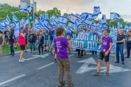 Haifa, Israel - July 08, 2023: People marching with flags and various signs. Week 27 of anti-government protest in Haifa, Israelのeditorial素材
