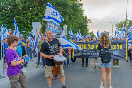 Haifa, Israel - July 08, 2023: People marching with flags and various signs. Week 27 of anti-government protest in Haifa, Israelのeditorial素材