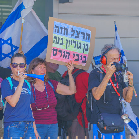 Haifa, Israel - July 18, 2023: People protest with flags and various signs in a train station. Part of day of disruption against controversial judicial overhaul, in Haifa, Israelのeditorial素材