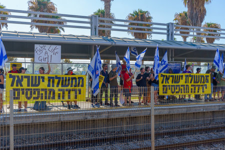 Haifa, Israel - July 18, 2023: People protest with flags and various signs in a train station. Part of day of disruption against controversial judicial overhaul, in Haifa, Israelのeditorial素材