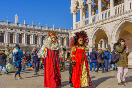 Venice, Italy - February 28, 2022: Group dressed in traditional costumes, in Riva degli Schiavoni waterfront, part of the Venice Mask Carnival, Veneto, Italyのeditorial素材