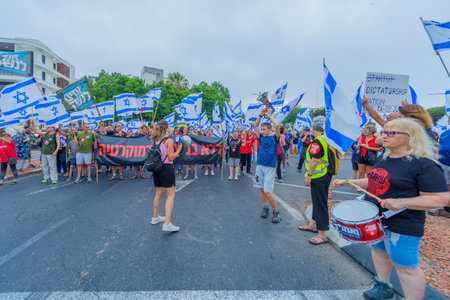 Haifa, Israel - August 12, 2023: People march with various flags and signs. Week 32 of protest against controversial judicial overhaul. Haifa, Israelのeditorial素材