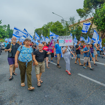 Haifa, Israel - August 12, 2023: People march with various flags and signs. Week 32 of protest against controversial judicial overhaul. Haifa, Israelのeditorial素材