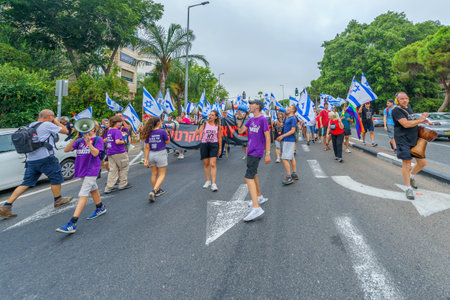 Haifa, Israel - August 12, 2023: People march with various flags and signs. Week 32 of protest against controversial judicial overhaul. Haifa, Israelのeditorial素材