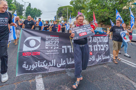 Haifa, Israel - August 12, 2023: People march with anti-occupation signs. Part of week 32 of protest against controversial judicial overhaul. Haifa, Israelのeditorial素材