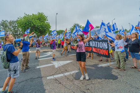Haifa, Israel - August 12, 2023: People march with various flags and signs. Week 32 of protest against controversial judicial overhaul. Haifa, Israelのeditorial素材