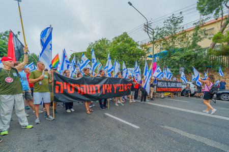 Haifa, Israel - August 12, 2023: People march with various flags and signs. Week 32 of protest against controversial judicial overhaul. Haifa, Israelのeditorial素材