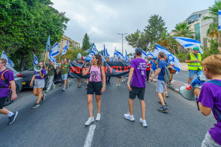 Haifa, Israel - August 12, 2023: People march with various flags and signs. Week 32 of protest against controversial judicial overhaul. Haifa, Israelのeditorial素材