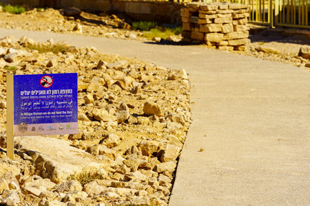 Mitzpe Ramon, Israel - August 11, 2023: Trilingual sign calling not to feed the ibex, and landscape of Makhtesh (crater) Ramon, in the Negev Desert, Southern Israelのeditorial素材