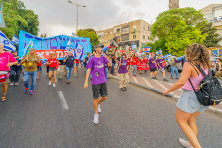 Haifa, Israel - August 26, 2023: People march with various signs and flags, led by air force pilots....