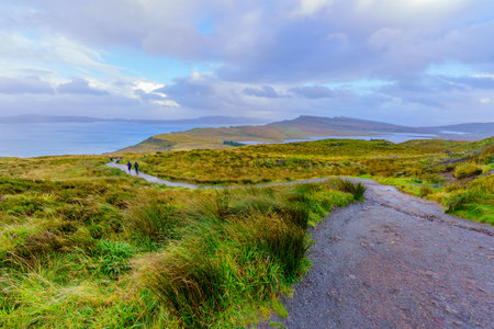 Portree, UK - September 30, 2022: Sunset view of rocks and grass with hikers along the Old Man of Storr path, in the Isle of Skye, Inner Hebrides, Scotland, UKのeditorial素材