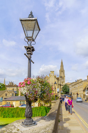 Stamford, UK - September 22, 2022: View of the Stamford bridge over the Welland River, and the Saint Mary church, with locals and visitors, in Stamford, Lincolnshire, England, UKのeditorial素材